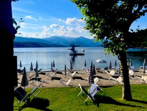 a group of chairs sitting on the shore of a lake at Camelia Riviera D'Orta in Gozzano