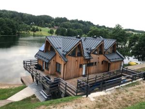 a large wooden house on a dock on a lake at Stanica MODRAK - Najpiekniejszy ZAKĄTEK KASZUB in Ręboszewo