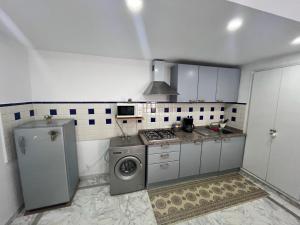 a kitchen with a stove and a washing machine at Appartement slim centre sousse in Sousse