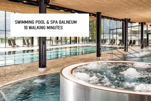 a hot tub in a swimming pool and spa bathroom with a sign at T-Collection Premium Apartments in Vipiteno