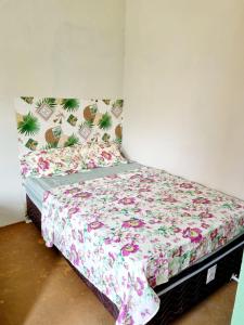 a bedroom with a bed with a floral bedspread at Suíte estrela do sal in Salinópolis