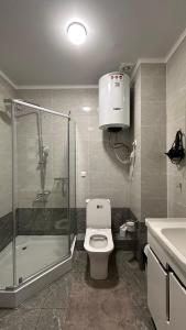 a bathroom with a shower and a toilet and a sink at Двух этажный таунхаус в 100 метрах от берега in Cholpon-Ata +18 photos