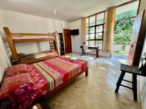 a bedroom with a bed and a desk and window at Stone House Mancora in Máncora