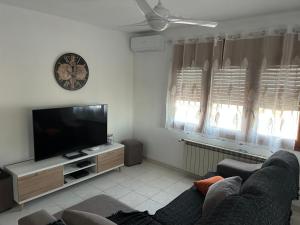 a living room with a couch and a flat screen tv at COLOMBIA piscina privada in Miami Platja