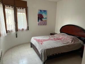 a bedroom with a bed and a picture on the wall at COLOMBIA piscina privada in Miami Platja +21 photos