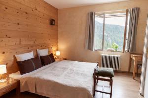a bedroom with a bed with a wooden wall at Hôtel du Grand Capelet in Belvédère