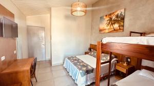 a bedroom with a bunk bed and a table at Pousada Praia Grande in Ubatuba +68 photos