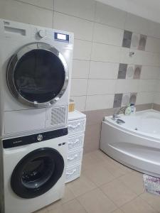 a washing machine in a bathroom next to a tub at SYS Apartament in Constanţa +25 photos