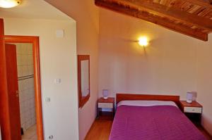 a bedroom with a bed with a purple blanket at Apartment Mario in Sumartin