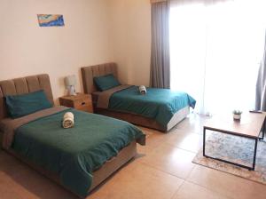a bedroom with two beds and a table at Royal Life Poseidon Residences Long Beach in Iskele +22 photos