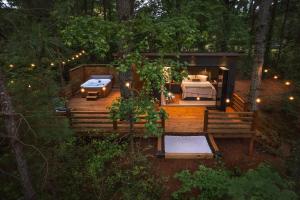 a wooden deck with a bed in a cabin in the woods at Luxury tiny cottage with deck hammock and hot tub! in Guntersville
