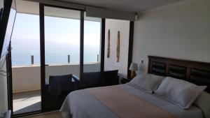 a bedroom with a bed with a view of the ocean at Jardin del Mar, Enjoy La Serena in Coquimbo
