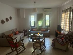 a living room with a couch and a table and chairs at A casa d Irene in Koropi