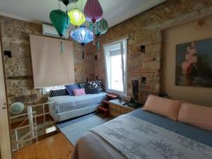 a room with a bed and a couch and chandeliers at Mastixi in Chios