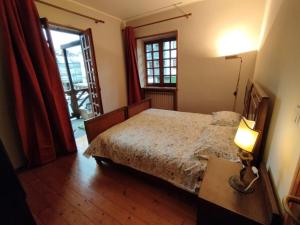 a bedroom with a bed and a table with a lamp at Stone House Viù-Location Orange in Viù