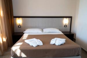 a bedroom with a bed with two white towels on it at Park Hotel Cilento in Marina di Camerota