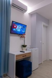una stanza con una scrivania con una TV a parete di Twins Hotel a Ksamil