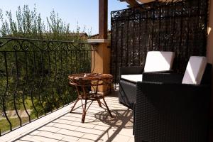 a patio with two chairs and a table and a fence at Park Hotel Cilento in Marina di Camerota