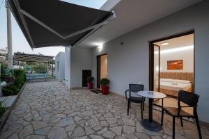 a room with a patio with a table and chairs at Twins Hotel in Ksamil