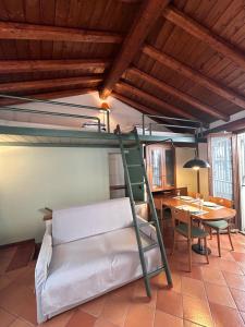 a room with a bunk bed and a dining room with a table at Casa Borgo in Lenno