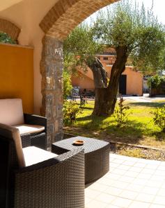 a patio with wicker chairs and a table and a tree at Park Hotel Cilento in Marina di Camerota +54 photos