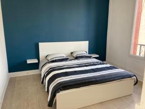 a bedroom with a bed with a blue wall at Belle maison avec grande terasse à 10 minutes en train de Paris centre et 6 min à pied de la gare et du centre ville in Colombes