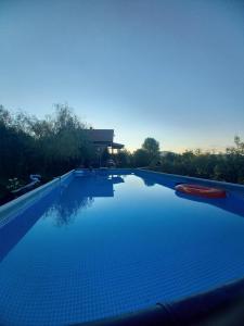 a swimming pool with blue water in front of a building at Green Idylle -Pyramid View in Visoko