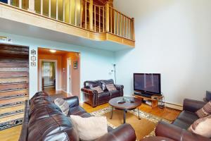 a living room with a couch and a tv at Timberline Chalet in Breckenridge