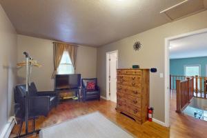 a living room with a tv and a dresser at Timberline Chalet in Breckenridge