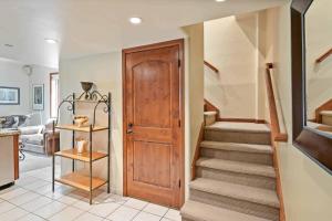 a hallway with a staircase and a wooden door at Lodge at Lionshead 310 in Vail +7 photos