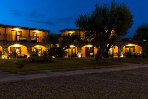 a building with a tree in front of it at night at Park Hotel Cilento in Marina di Camerota