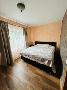 a bedroom with a bed and a window at Rožu namu apartamenti 2 in Kuldīga