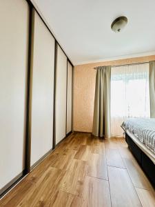 a bedroom with a bed and a large window at Rožu namu apartamenti 2 in Kuldīga