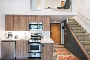 a kitchen with a stove top oven next to a staircase at Lodge at Lionshead 320 in Vail
