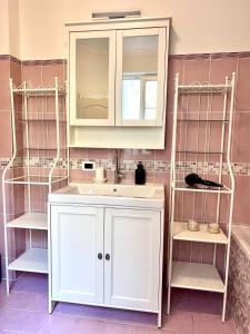 a bathroom with a white sink and shelves at Suite Mitteleuropa private parking in Trieste +57 photos