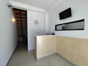 a room with a counter and a tv on the wall at Fiori Apartment in Gevgelija