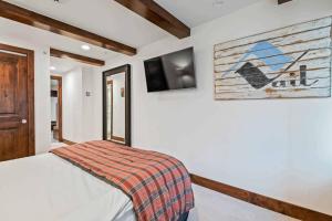 Un dormitorio con una cama y un televisor en la pared. en Lodge at Lionshead 403, en Vail