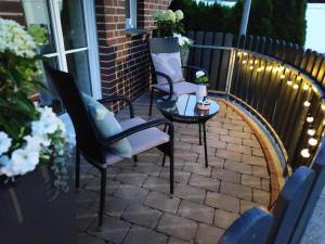2 Stühle und ein Tisch auf einer Terrasse mit Licht in der Unterkunft Apartment Marissa in Billerbeck