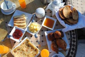 einen Tisch mit verschiedenen Frühstücksvarianten in der Unterkunft Riad Dar Selen in Marrakesch