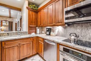 a kitchen with wooden cabinets and stainless steel appliances at Lodge at Lionshead 404 in Vail