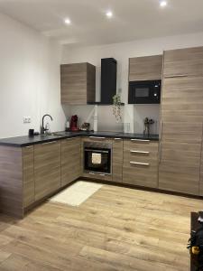 a kitchen with wooden cabinets and a stove top oven at Charmant appartement in Bandol