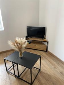 a living room with a table and a tv at Charmant appartement in Bandol