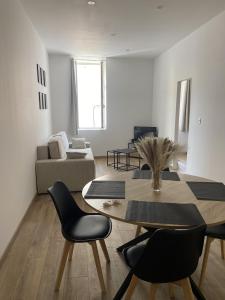a living room with a table and chairs and a couch at Charmant appartement in Bandol