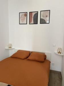 a bedroom with a bed with three pictures on the wall at Charmant appartement in Bandol