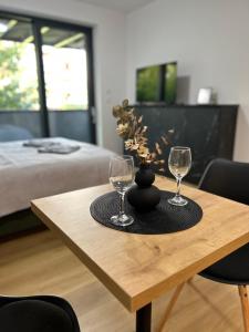 a table with two wine glasses and a vase on it at AR TAHITI black in Košice