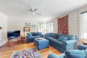 a living room with blue couches and a tv at Walk to Town! Dog-Friendly Quincy Getaway w/ Deck in Quincy
