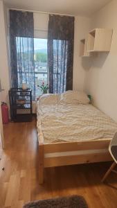 a bedroom with a bed and a large window at City housing in Stavanger