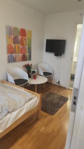a bedroom with a tv and a table and chairs at City housing in Stavanger