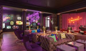 a dining room with couches and a stage with purple curtains at Nickelodeon Hotels & Resorts Punta Cana - Gourmet All Inclusive by Karisma in Punta Cana