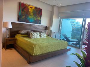 a bedroom with a bed and a chair and a painting at Peninsula Nuevo Vallarta in Mezcales +26 photos